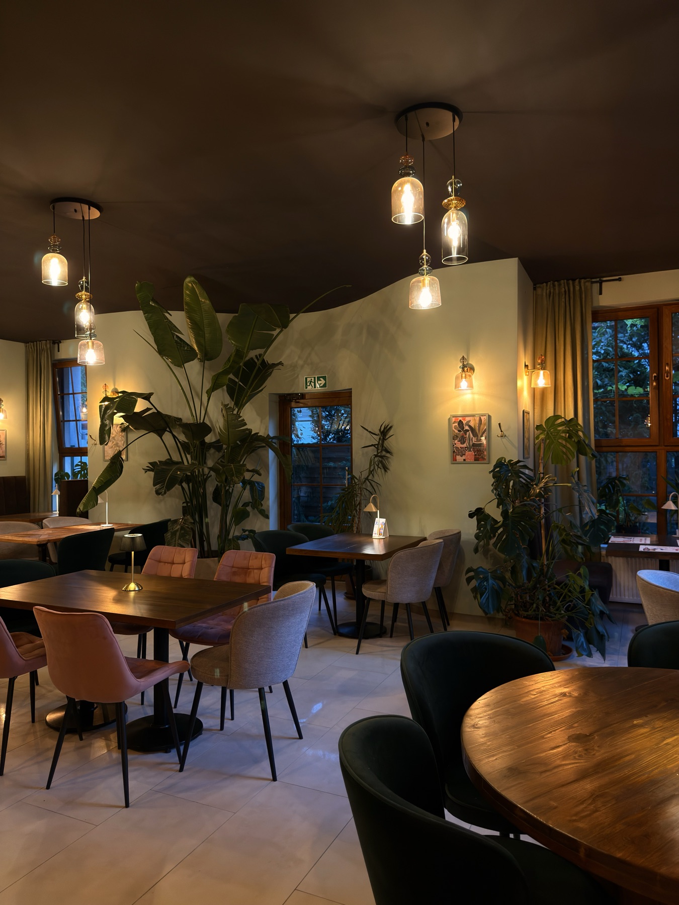 Sala Pizzerii Ogrodowej w Wieluniu — zielone wnętrze i stoliki